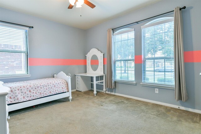 carpeted bedroom with multiple windows and ceiling fan