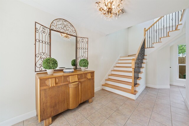 staircase featuring ornamental molding, tile patterned floors, and an inviting chandelier