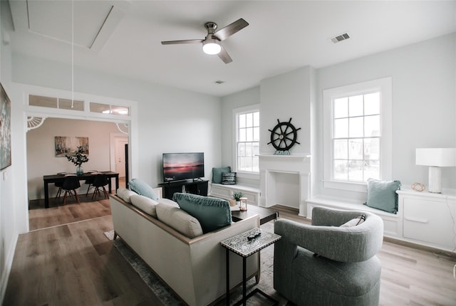 living room with hardwood / wood-style floors, a fireplace, and ceiling fan