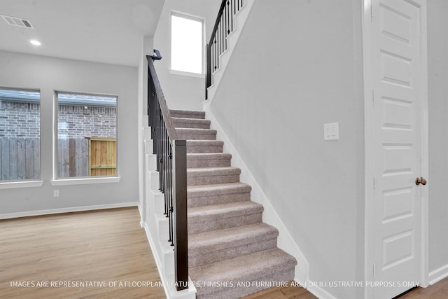 stairway with visible vents, recessed lighting, baseboards, and wood finished floors