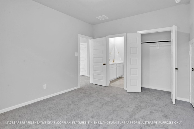 unfurnished bedroom featuring baseboards, visible vents, ensuite bath, a closet, and carpet flooring