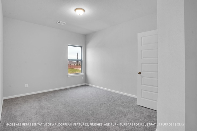 carpeted spare room with visible vents and baseboards