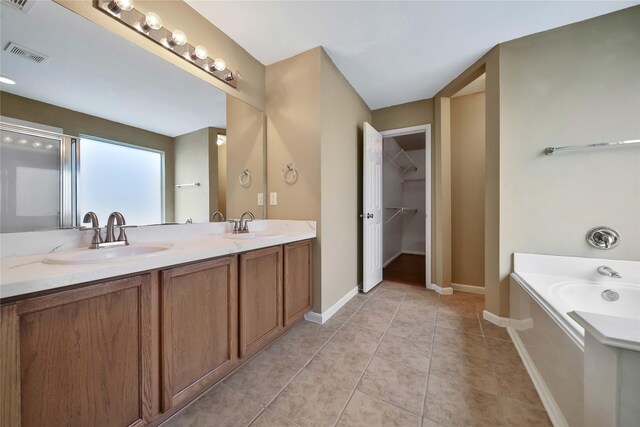 bathroom featuring tile patterned floors, vanity, and shower with separate bathtub