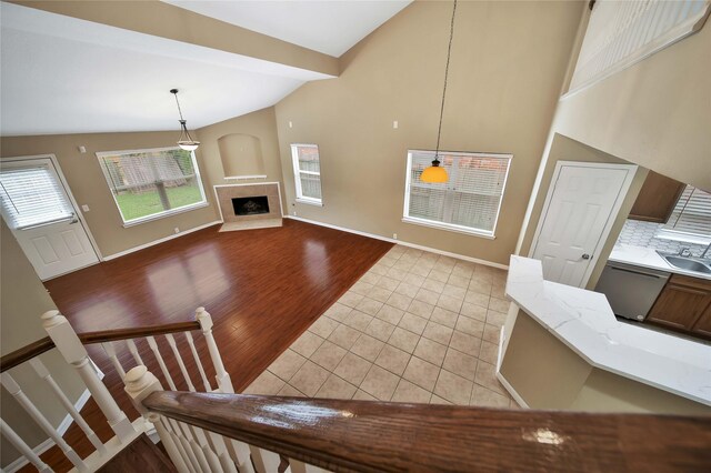 living room featuring sink, light tile patterned floors, and high vaulted ceiling