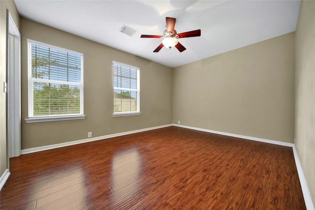 empty room featuring dark wood-type flooring and ceiling fan