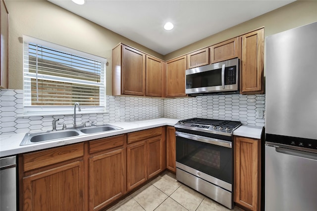 kitchen with sink, backsplash, stainless steel appliances, and light tile patterned floors