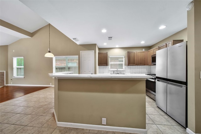 kitchen featuring a kitchen island, appliances with stainless steel finishes, pendant lighting, and light tile patterned floors