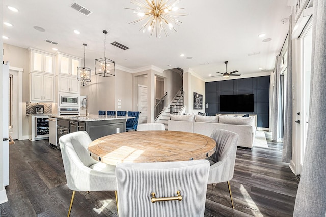 dining area featuring crown molding, sink, dark hardwood / wood-style floors, and beverage cooler