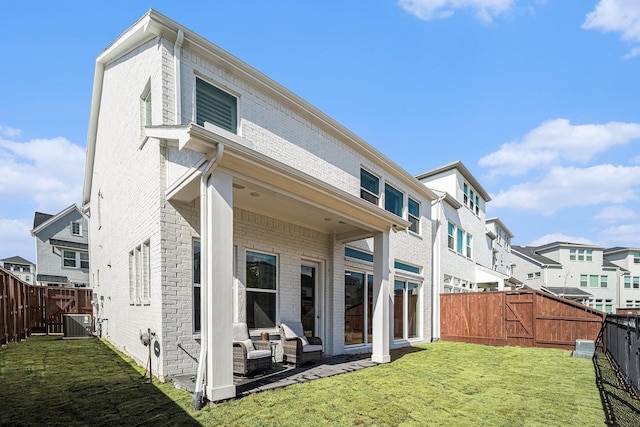 rear view of house with a lawn and central air condition unit