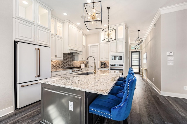 kitchen with stainless steel appliances, an island with sink, sink, and white cabinets