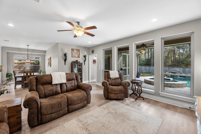 living room with ceiling fan, light hardwood / wood-style flooring, and a healthy amount of sunlight