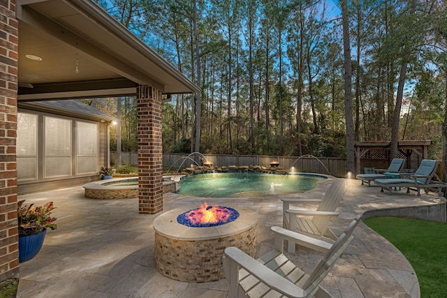 view of swimming pool with pool water feature, an outdoor fire pit, a hot tub, and a patio area