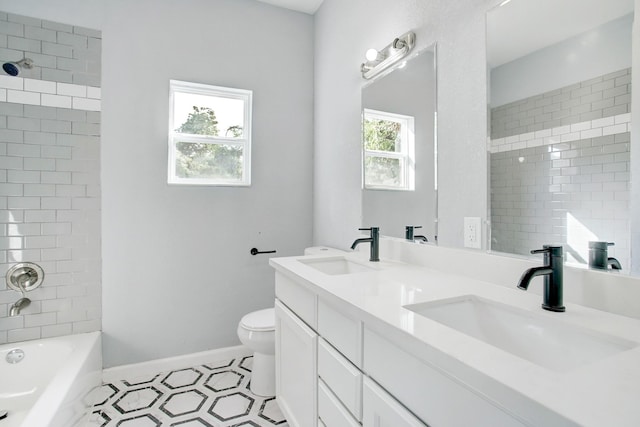 full bathroom with tiled shower / bath, vanity, and toilet