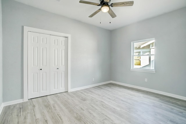 unfurnished bedroom featuring ceiling fan, a closet, and light hardwood / wood-style flooring