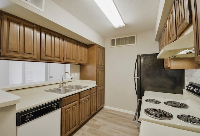 kitchen with sink, dishwasher, refrigerator, range with electric stovetop, and light hardwood / wood-style floors