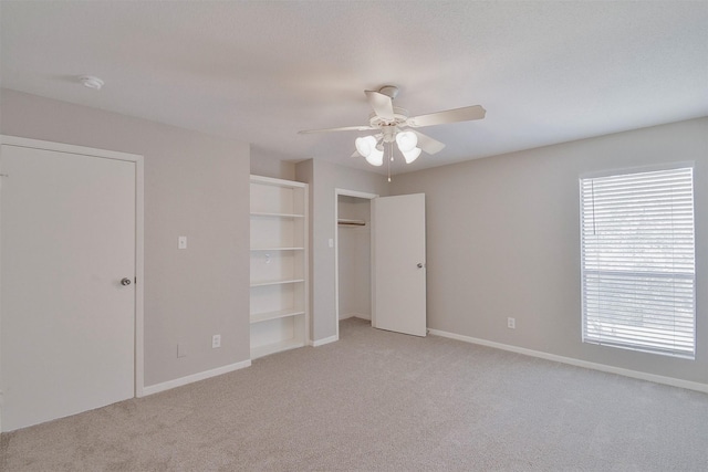 unfurnished bedroom featuring light colored carpet, ceiling fan, and a closet