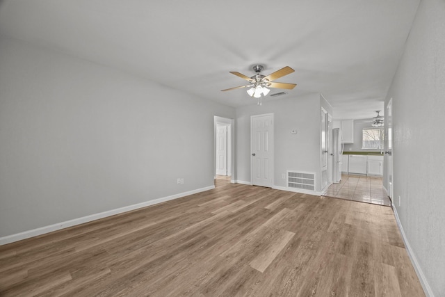 unfurnished living room featuring a ceiling fan, light wood-type flooring, and baseboards