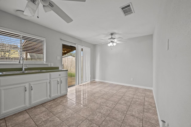 interior space featuring a sink, a ceiling fan, visible vents, white cabinetry, and dark countertops