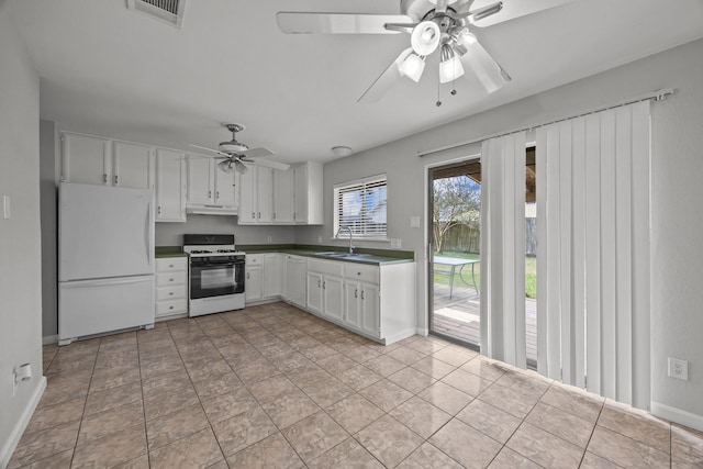 kitchen featuring white appliances, a sink, visible vents, white cabinetry, and dark countertops