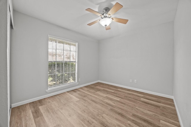 unfurnished room with ceiling fan, wood finished floors, and baseboards