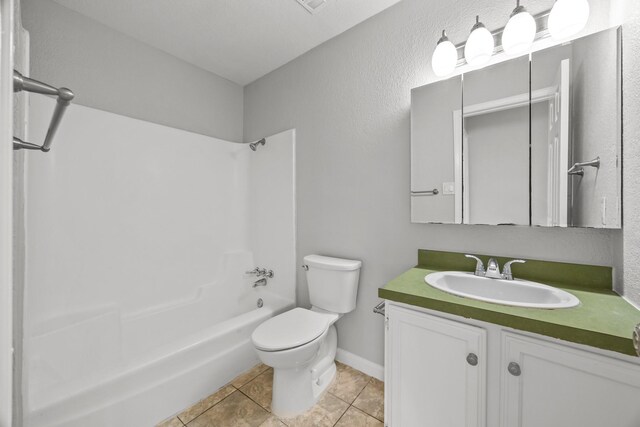full bathroom with toilet, washtub / shower combination, tile patterned floors, vanity, and a textured wall