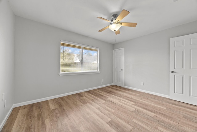 spare room with light wood-style floors, baseboards, and a ceiling fan