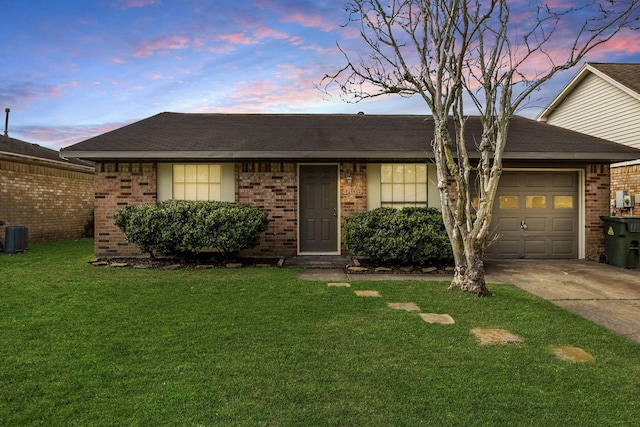 view of front of home with brick siding, a garage, a front yard, and concrete driveway