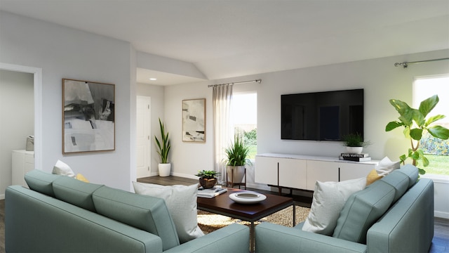 living room with a healthy amount of sunlight, vaulted ceiling, and hardwood / wood-style floors