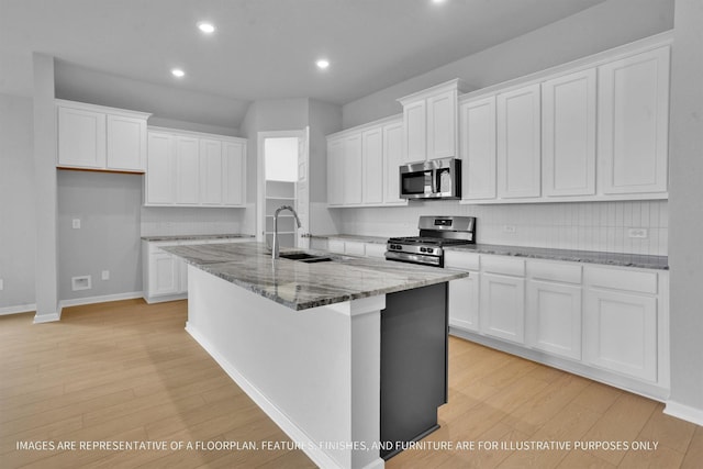 kitchen with appliances with stainless steel finishes, white cabinetry, and a sink