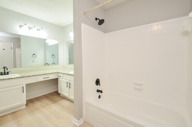 bathroom with wood-type flooring, tub / shower combination, and vanity