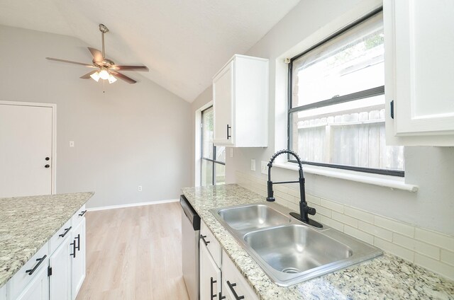 kitchen with white cabinetry, sink, and vaulted ceiling