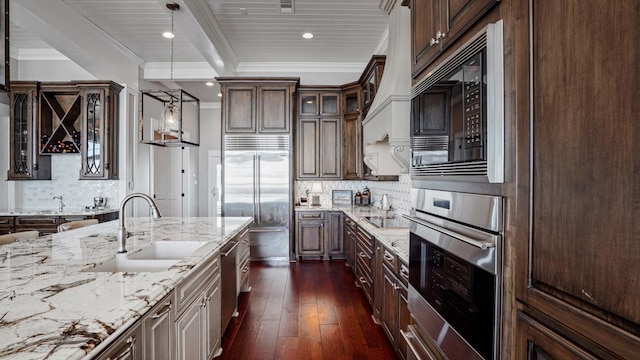 3450 Smiths Pt, Crystal Beach, TX 77650 - kitchen featuring sink, hanging light fixtures, dark brown cabinetry, black appliances, and light stone countertops