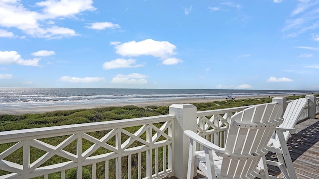 balcony featuring a water view and a beach view