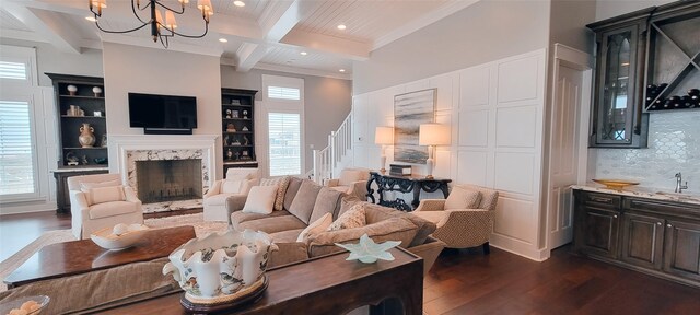3450 Smiths Pt, Crystal Beach, TX 77650 - living room featuring dark hardwood / wood-style flooring, a chandelier, coffered ceiling, a premium fireplace, and beam ceiling