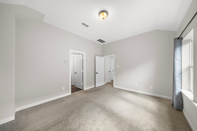 unfurnished bedroom featuring vaulted ceiling and carpet flooring