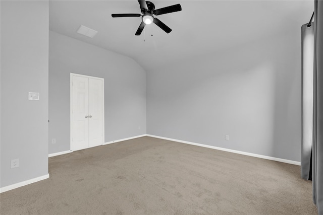 empty room featuring lofted ceiling, carpet flooring, and ceiling fan