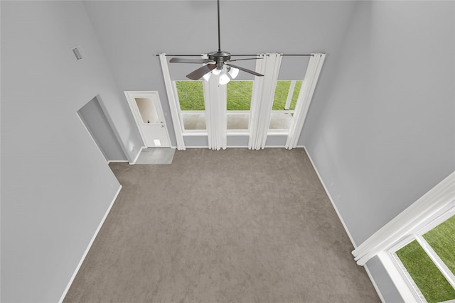 unfurnished living room featuring ceiling fan and light colored carpet