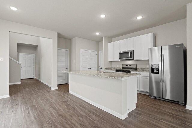 kitchen featuring white cabinetry, appliances with stainless steel finishes, a kitchen island with sink, dark wood-style flooring, and a sink