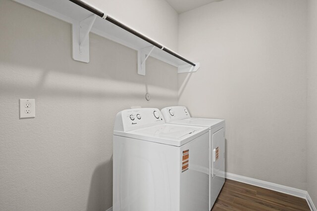 laundry room featuring dark wood-type flooring, baseboards, separate washer and dryer, and laundry area