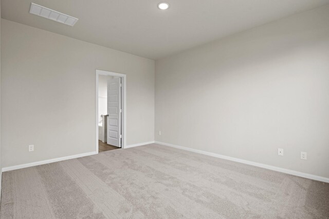 carpeted spare room featuring visible vents, baseboards, and recessed lighting