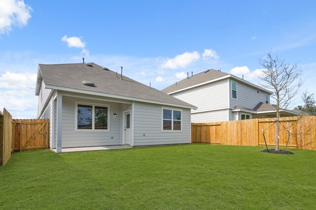 rear view of property with a fenced backyard and a lawn
