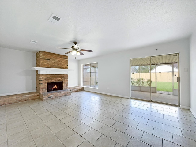 unfurnished living room with a textured ceiling, a fireplace, and a healthy amount of sunlight