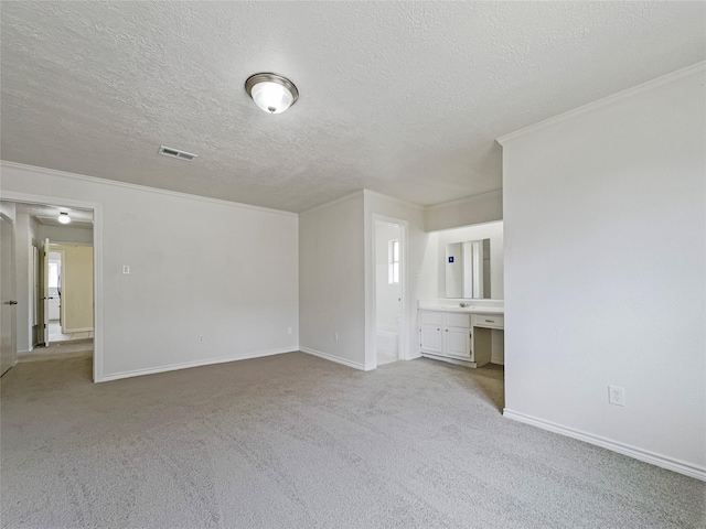 carpeted empty room with crown molding, plenty of natural light, and a textured ceiling