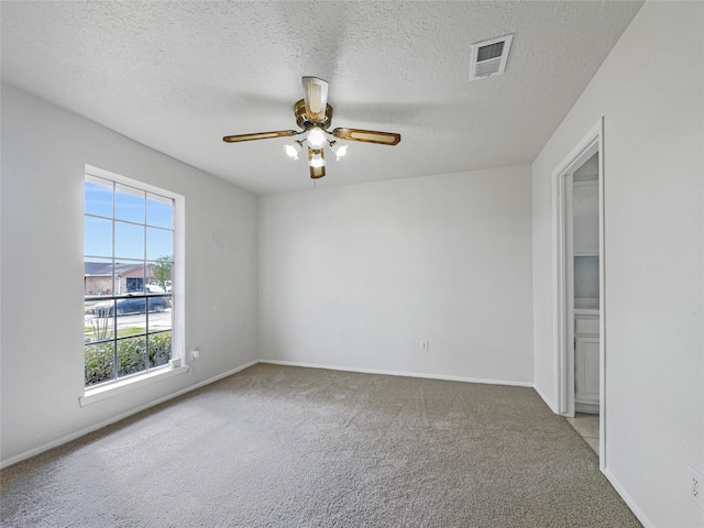 carpeted empty room featuring a textured ceiling and ceiling fan