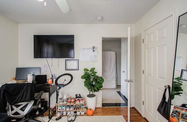 office space featuring ceiling fan, wood-type flooring, and a textured ceiling