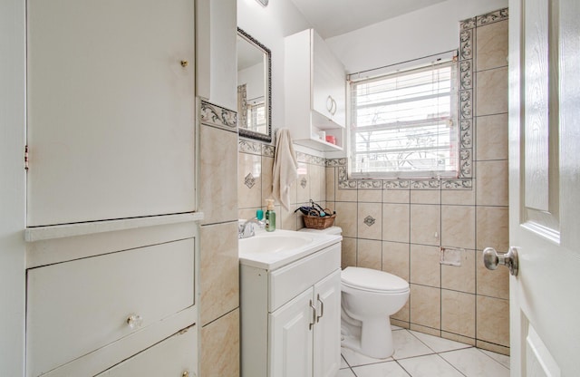 bathroom featuring vanity, tile patterned flooring, toilet, and tile walls