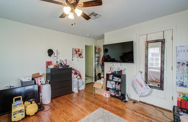 interior space with ceiling fan, wood-type flooring, and a textured ceiling