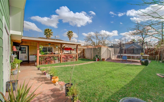 view of yard with a trampoline and a patio area