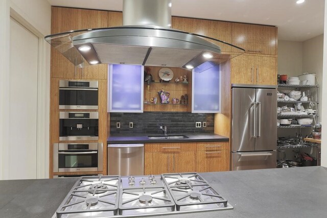 kitchen with sink, backsplash, island exhaust hood, and appliances with stainless steel finishes