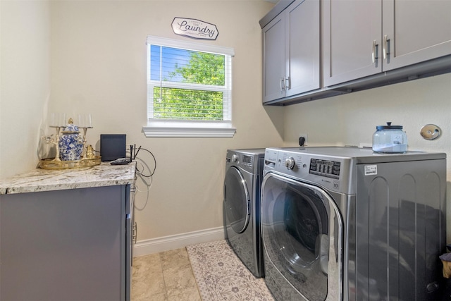 laundry area with cabinets and washing machine and clothes dryer